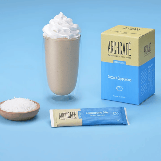 Archicafé Coconut Cappuccino with packaging, coffee pod, and bowl of coconut on a blue background